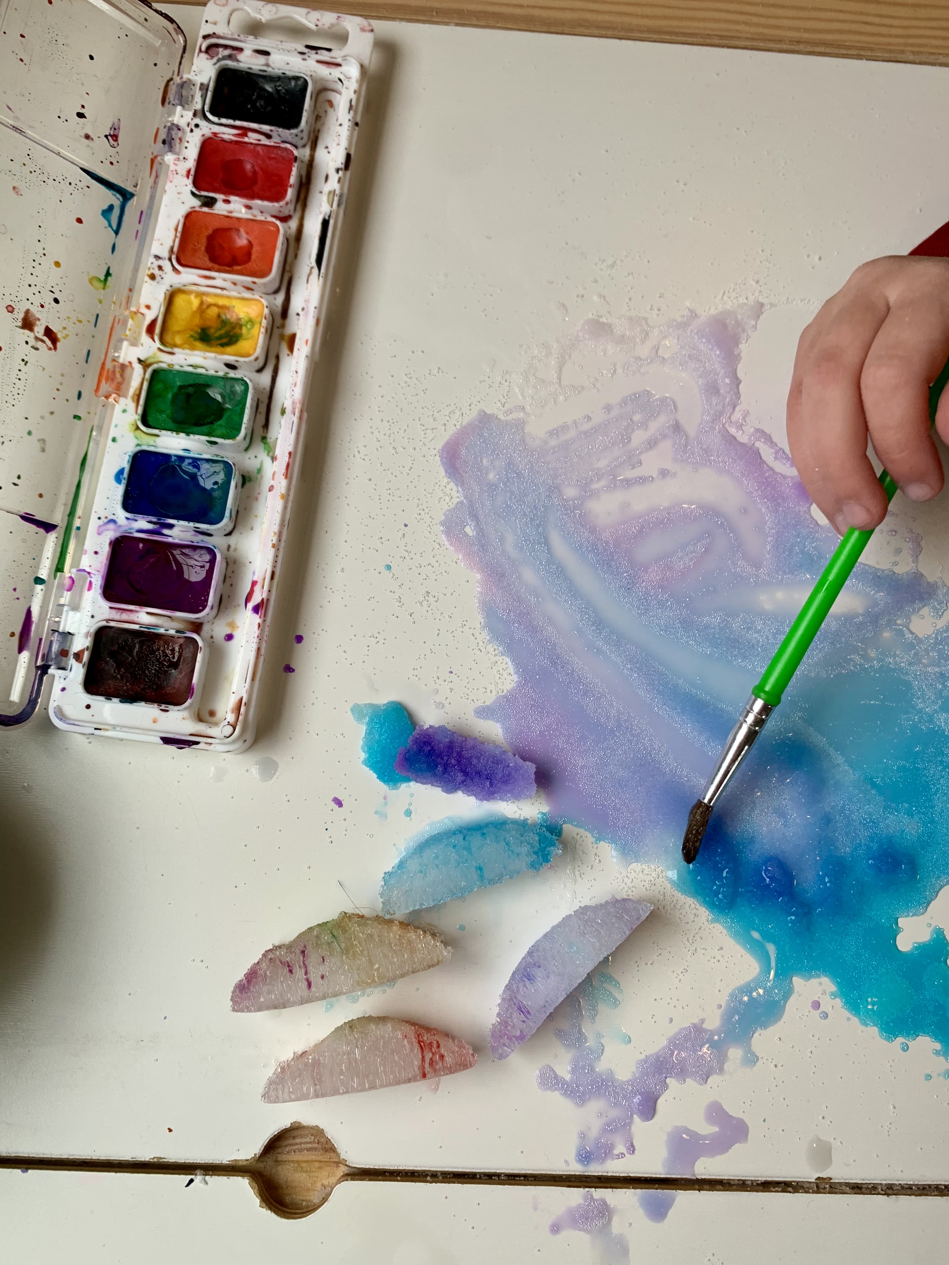 Water color paint on ice cubes with salt