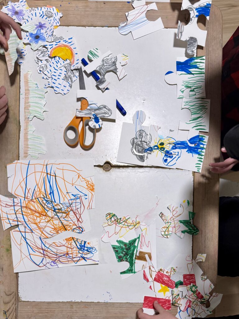 Four kids assembling hand made puzzles in honor of National Puzzle Day. 