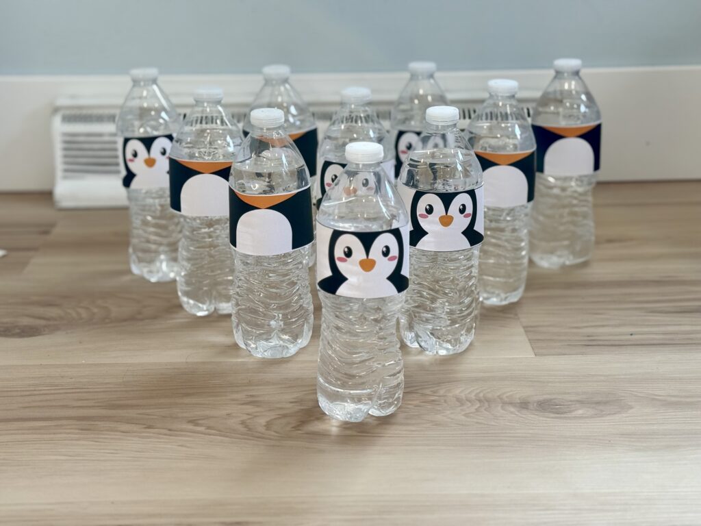 Penguin bowling, water bottles with penguin labels lined up like bowling pins