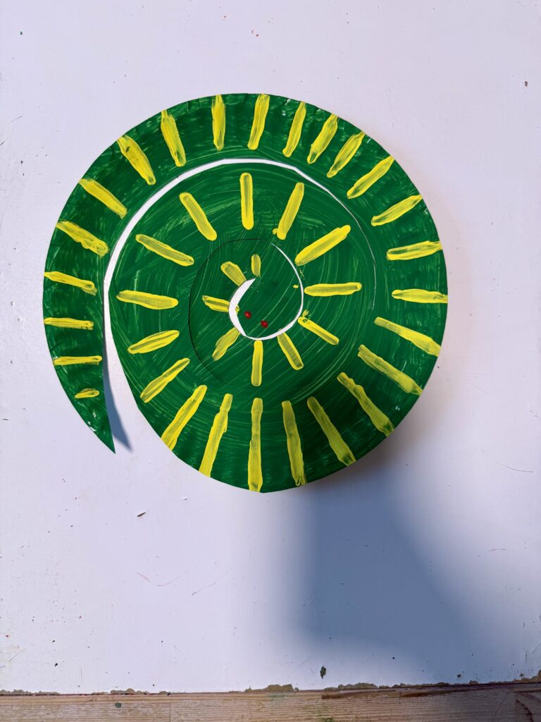 Year of the Snake craft: paper plate painted in snake design, cut in spiral to create a curled up snake